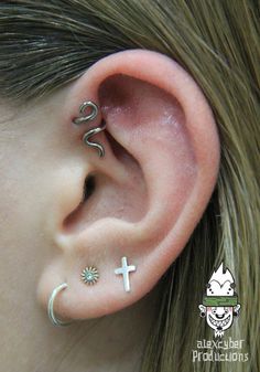 an ear with two piercings and a cross on the middle one is in white gold