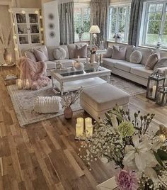 a living room filled with lots of furniture and flowers on top of a hard wood floor