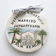 a ceramic ornament with the name and date for a wedding in front of palm trees