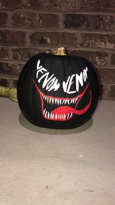 a black pumpkin decorated with an image of a monster's mouth and fangs on it