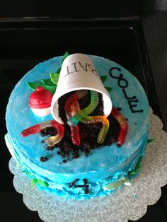 a birthday cake decorated with gummy worms and an ice cream cone that says i live cold