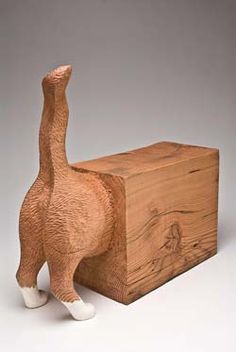 a wooden box with a carved giraffe figure on it's front and side