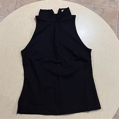 Washed But Never Used. Nice Thick Material. Mock Neck And Sleeveless. Chic Black High Neck Halter Top, Black High Neck Tank Top For Spring, Spring Black High Neck Tank Top, Fitted Halter Neck Top For Work, Black High Neck Tank Top For Night Out, Black Stretch Halter Neck Top, Black Sleeveless Vest Top, Black Stretch High Neck Tank Top, Casual Halter Neck Top For Work