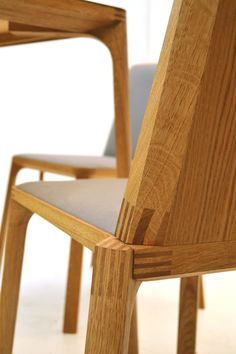 a close up of a wooden chair on a white floor with a light colored background