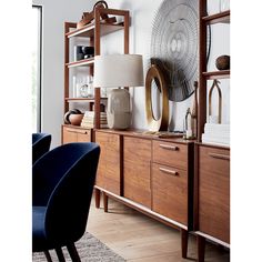 a living room filled with furniture next to a wall mounted clock on a wooden shelf