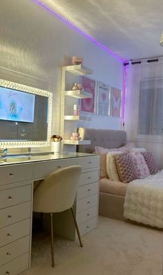 a bedroom with a bed, desk and television on the wall next to a window