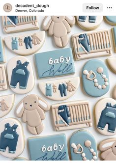 cookies decorated with blue and white icing are arranged in the shape of baby items