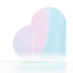 a heart shaped plate sitting on top of a white table next to a blue and pink vase