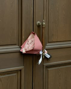 a pink paper bag on top of a door handle