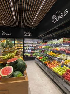 a produce section in a grocery store filled with fruits and vegetables