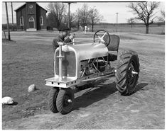 black and white photograph of an old farmallist driving a tractor in the country