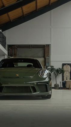 a green sports car parked in a garage