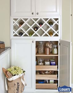 a kitchen with white cabinets and shelves filled with food