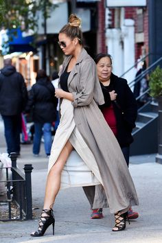 a woman is walking down the street wearing high heels