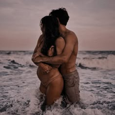 two people in the ocean hugging each other