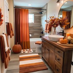 a bathroom decorated for fall with pumpkins and candles