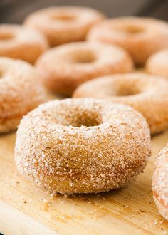 several sugared donuts on a wooden cutting board