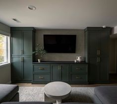 a living room filled with furniture and a flat screen tv mounted to the side of a wall