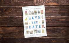 save the date card sitting on top of a wooden table