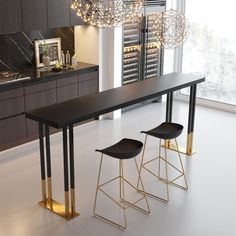 a table with two stools next to it in front of a large window and a chandelier