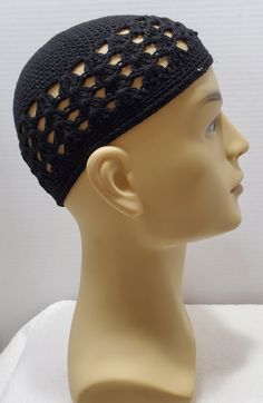 a mannequin head wearing a black crochet hat with holes on it