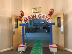 a football field is decorated with balloons and lights for the entrance to main gate at an indoor event