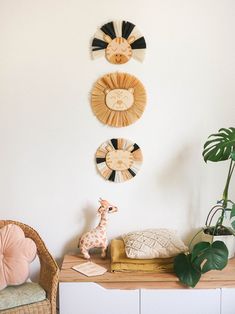 three wall clocks mounted to the side of a white wall next to a wooden table