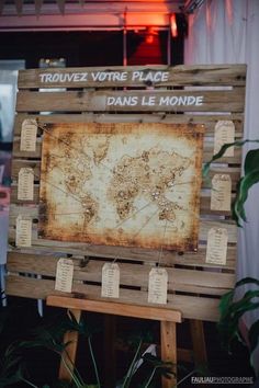 an old world map is displayed on a wooden easel