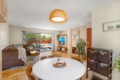 a living room filled with furniture and a flat screen tv sitting on top of a wooden table