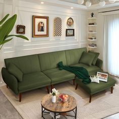 a living room with a green couch, coffee table and pictures on the wall above it