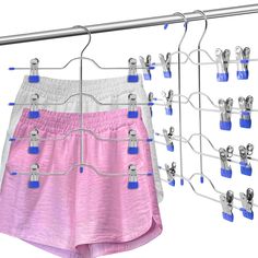 several pairs of shorts hanging on a clothes line with clips to hang them from hooks