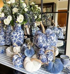 blue and white vases with flowers in them are sitting on a dining room table