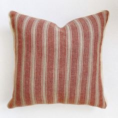 a red and white striped pillow on a white wall