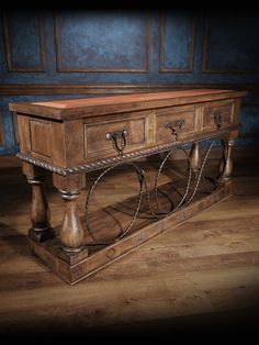 an old wooden table with metal handles on the top and bottom, sitting on a hard wood floor