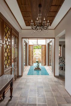 an indoor swimming pool in the middle of a room with chandelier above it