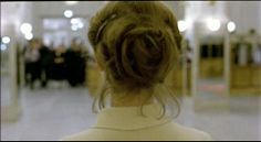 the back of a woman's head as she walks down a hallway