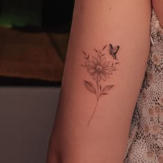 a woman's arm with a flower tattoo on the left side of her arm