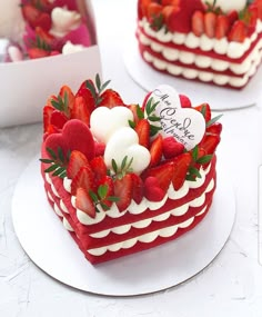 two heart shaped cakes decorated with strawberries and marshmallows