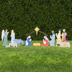 the nativity scene is made out of wood and painted in blue, green and yellow