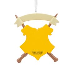 a yellow ornament with two crossed wooden sticks hanging from it's side