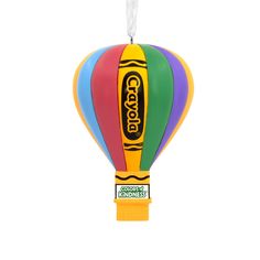 a colorful hot air balloon ornament hanging from a string on a white background