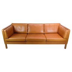 a brown leather couch sitting on top of a wooden frame