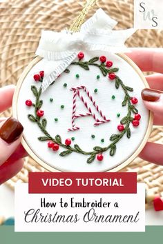 a hand holding a christmas ornament with the text video tutor how to embroder a christmas ornament