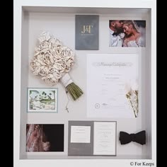 a white framed display with flowers and pictures