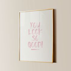 a white and gold framed poster with the words you look so good written in pink ink