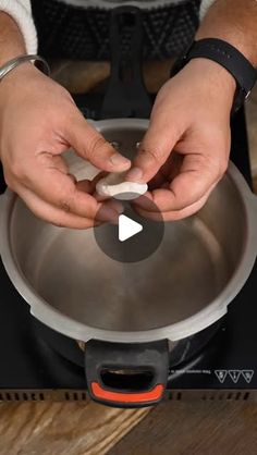 a person is placing something in a bowl on the stove top with their hands and fingers