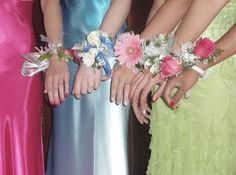 four bridesmaids in colorful dresses holding their bouquets