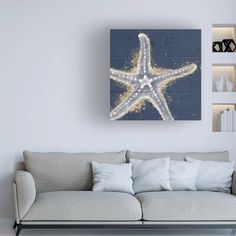 a living room with a couch, coffee table and starfish painting on the wall