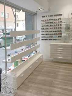 the inside of a store with lots of glasses on display and shelves full of sunglasses