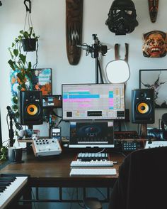 there is a computer on the desk in front of some speakers and other musical equipment